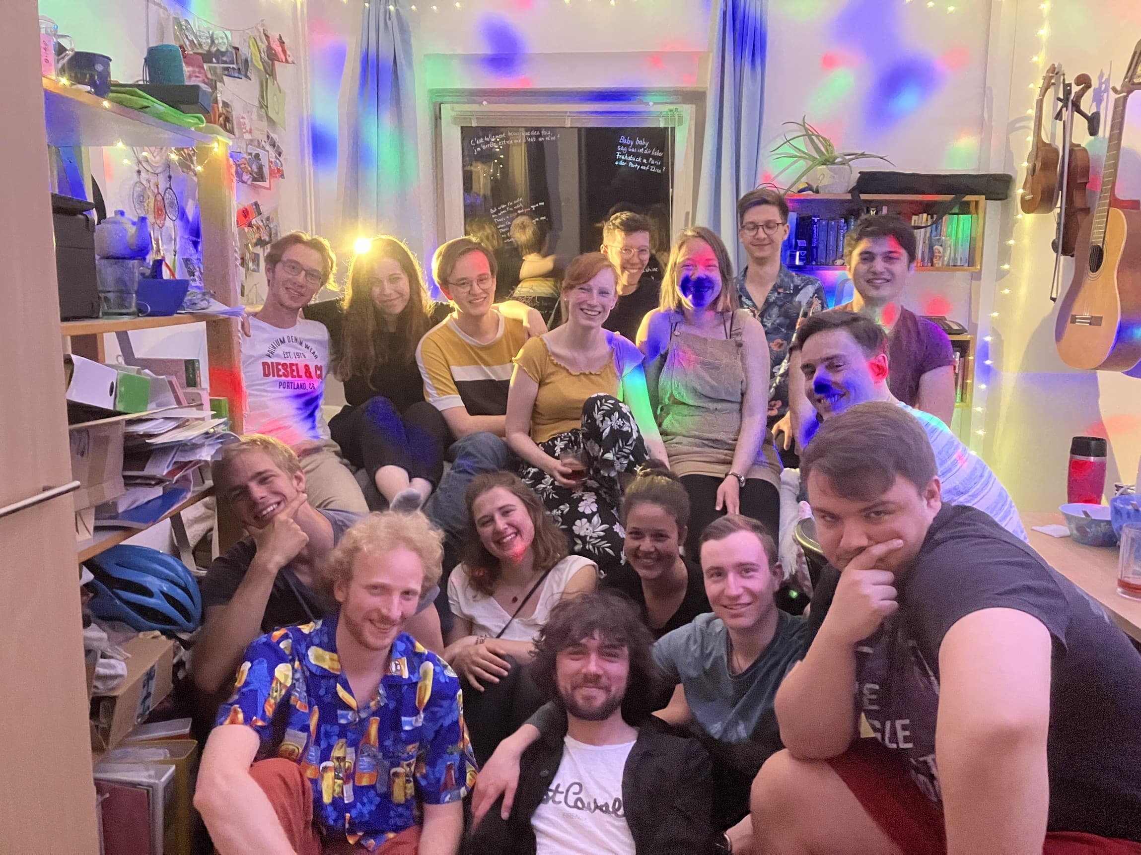 Gruppenbild auf einer 'Tour de Chambre', einer Party, bei der man durch die Zimmer der Etage geht und feiert. Einige Studierende sitzen in einem Zimmer und lachen