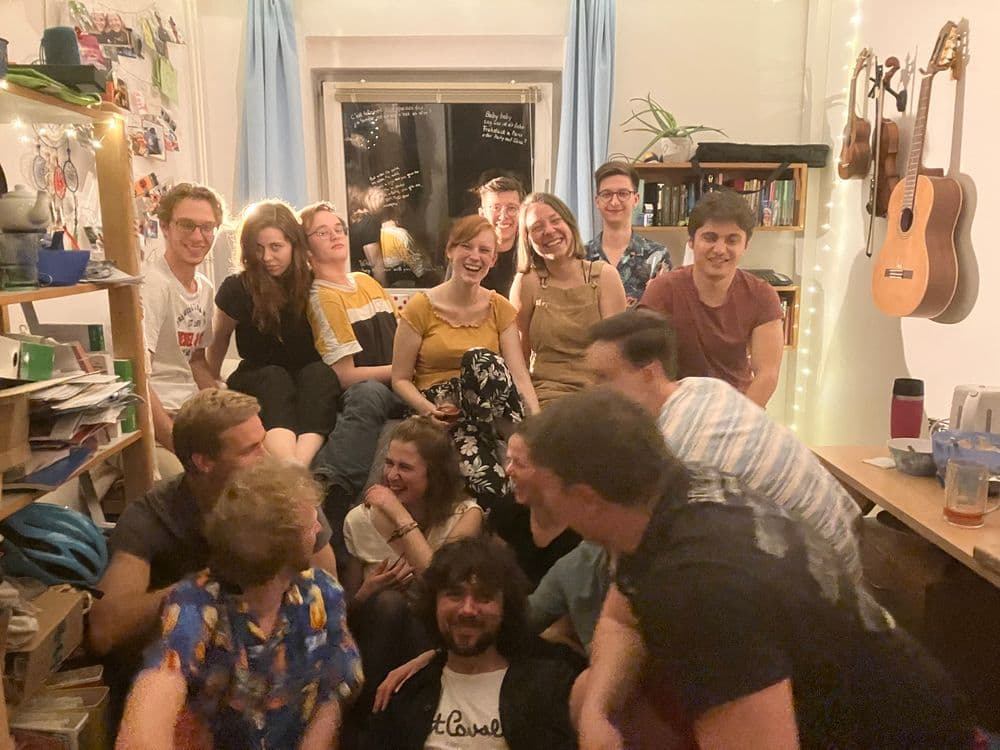 Gruppenbild auf einer 'Tour de Chambre', einer Party, bei der man durch die Zimmer der Etage geht und feiert. Einige Studierende sitzen in einem Zimmer und lachen