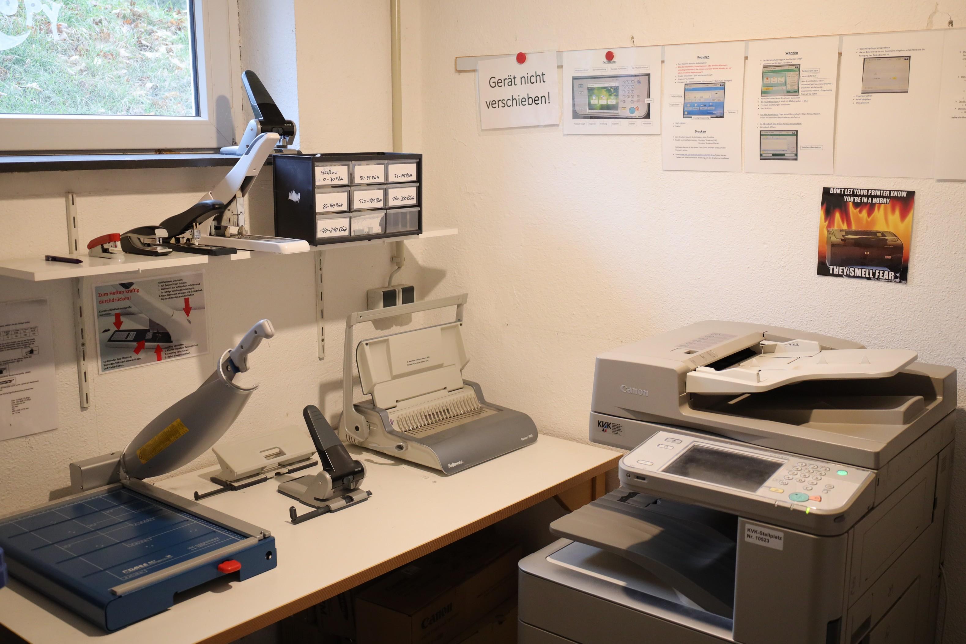 Ein Raum mit Drucker, Kopierer, Laminierer und Papierschneidemaschine