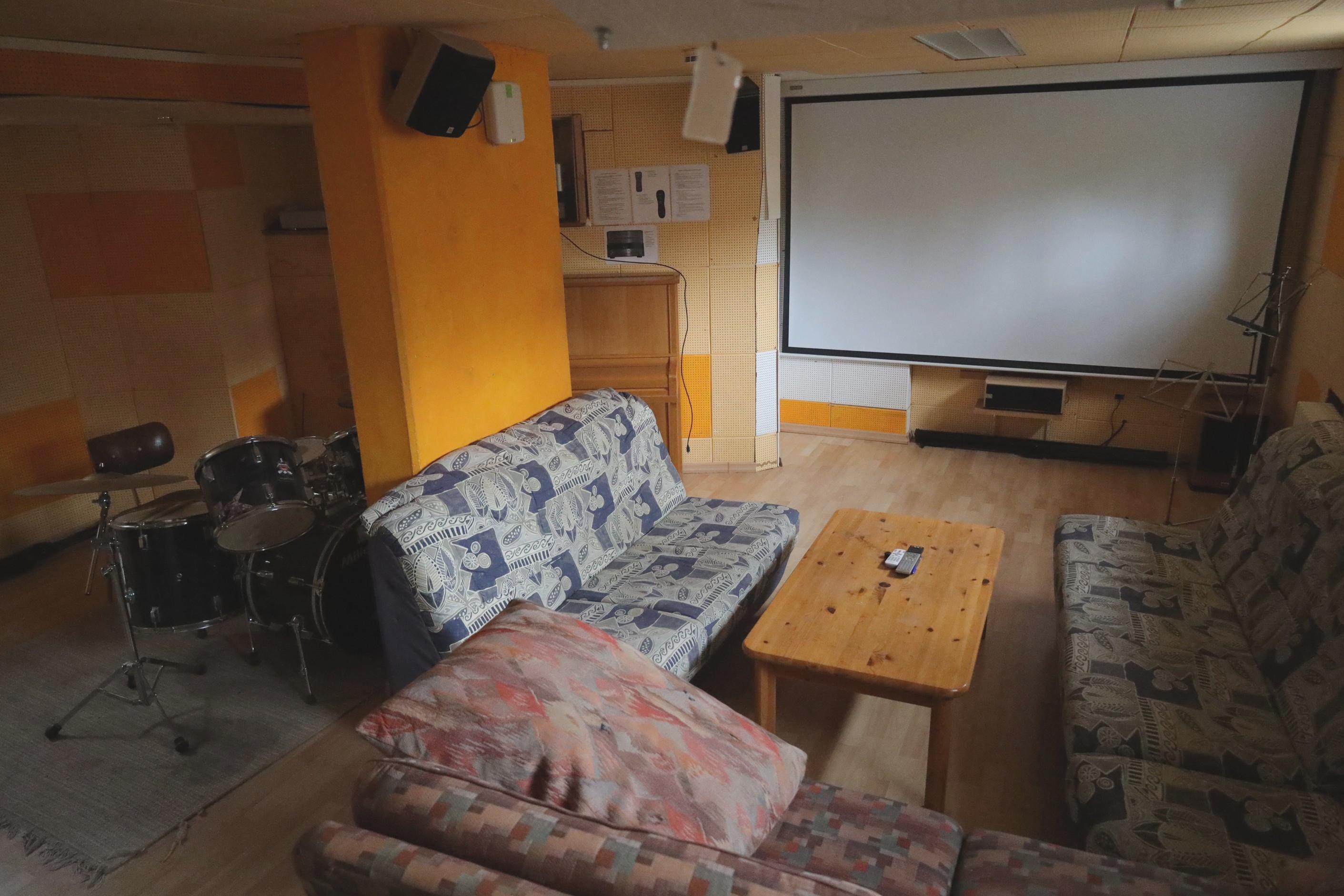 Ein Raum mit Sofas und einer großen Leinwand
