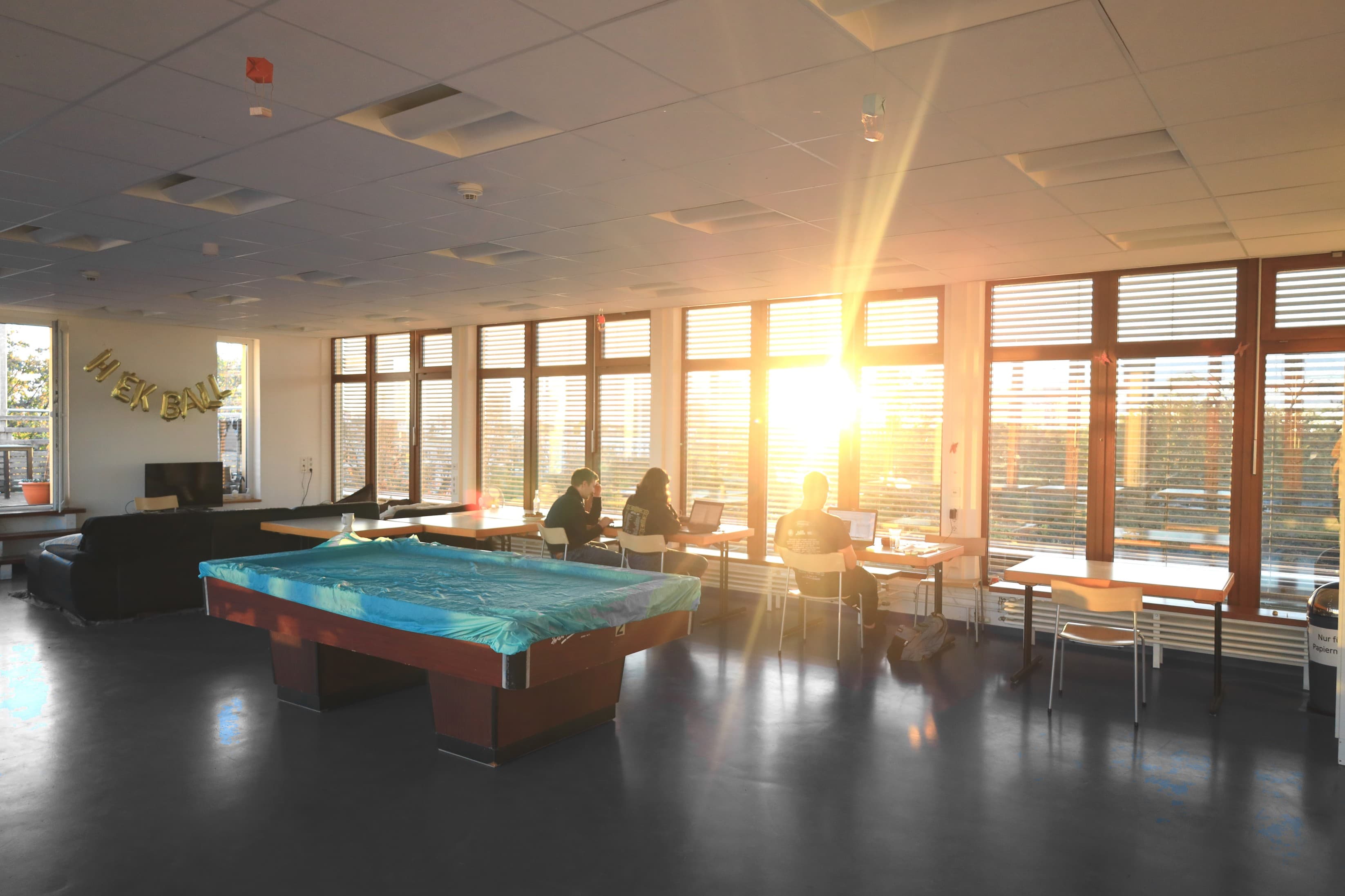 Der Hauseigene Saal an einem späten Sommernachmittag. Ein großer Saal mit Panoramafenstern bei Gegenlicht